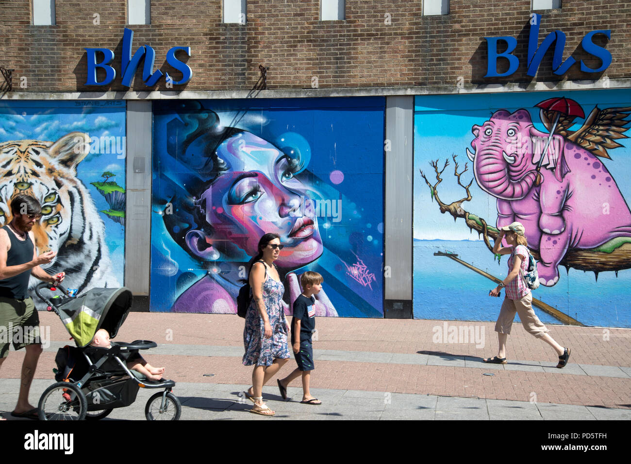 Southend on Sea, Essex. People walk past a closed down BHS (British Home Stores) shop now decorated with colorful street art Stock Photo