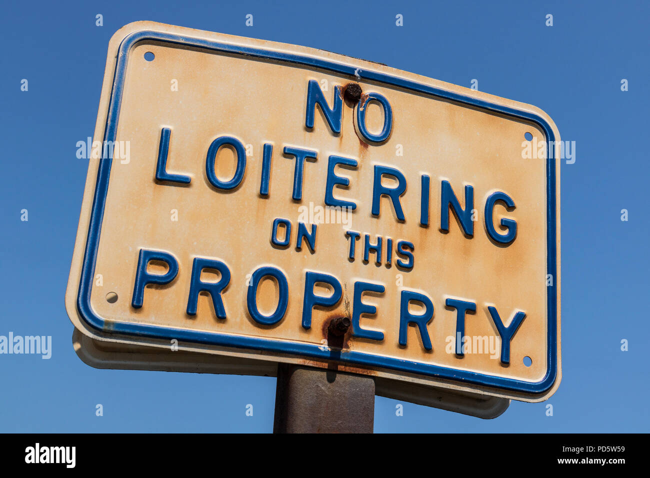 Aged and weathered No Loitering on this Property sign I Stock Photo