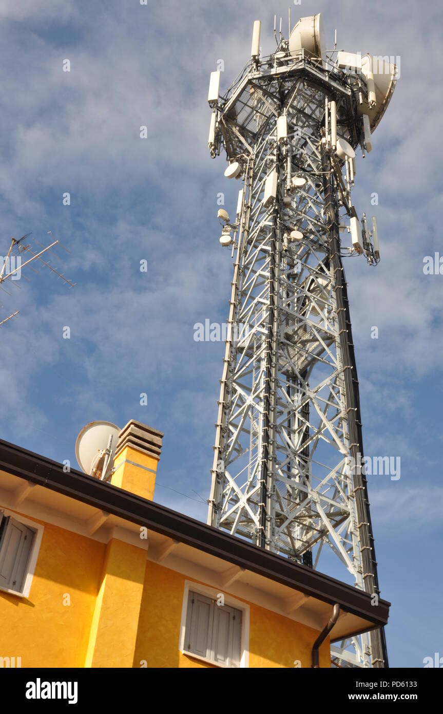 Telecommunication tower with antennas over the top of a building Stock Photo