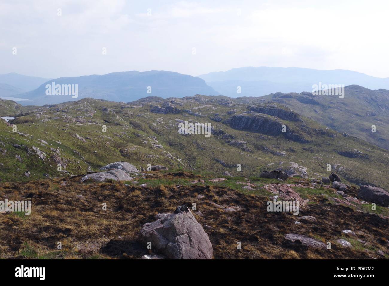 Vast Layered Rugged Rocky Landscape of Torridon, NW Scottish Highlands, UK. On a Hazy Summer's Afternoon. Stock Photo