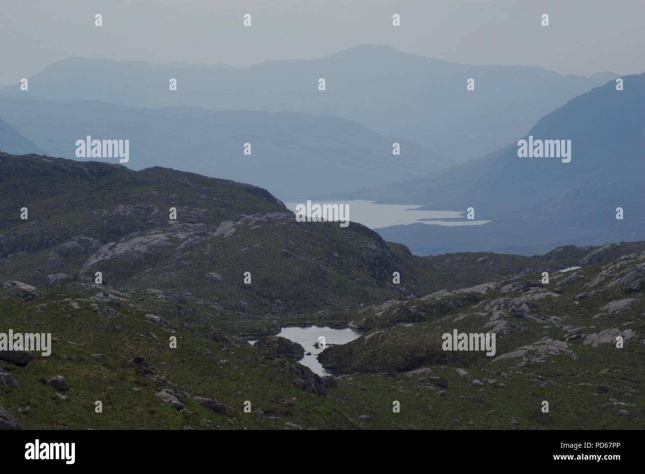 Rugged Rocky Landscape and Lochs of Torridon, NW Scottish Highlands, UK. On a Hazy Summer's Afternoon. Stock Photo