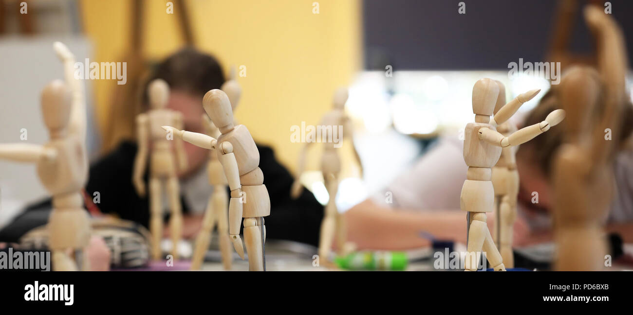 Visual Art high school students working from wooden mannequins practicing drawing human fugure and correct proportion. Artists being creative the art  Stock Photo