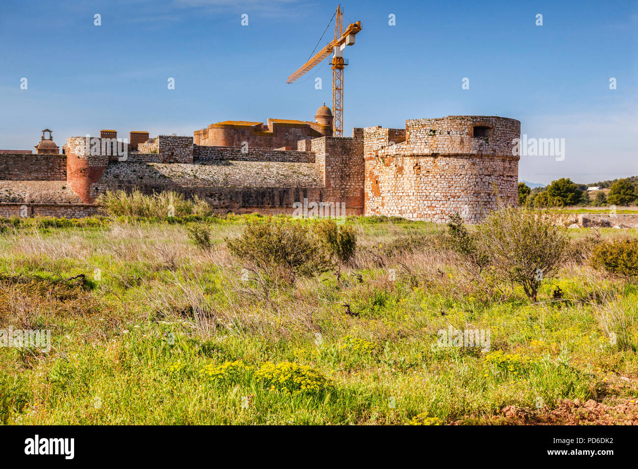 A crane towers over Fort de Salses, Salses-le-Chateau, Languedoc-Roussillon, Pyrenees-Orientales, France. Stock Photo