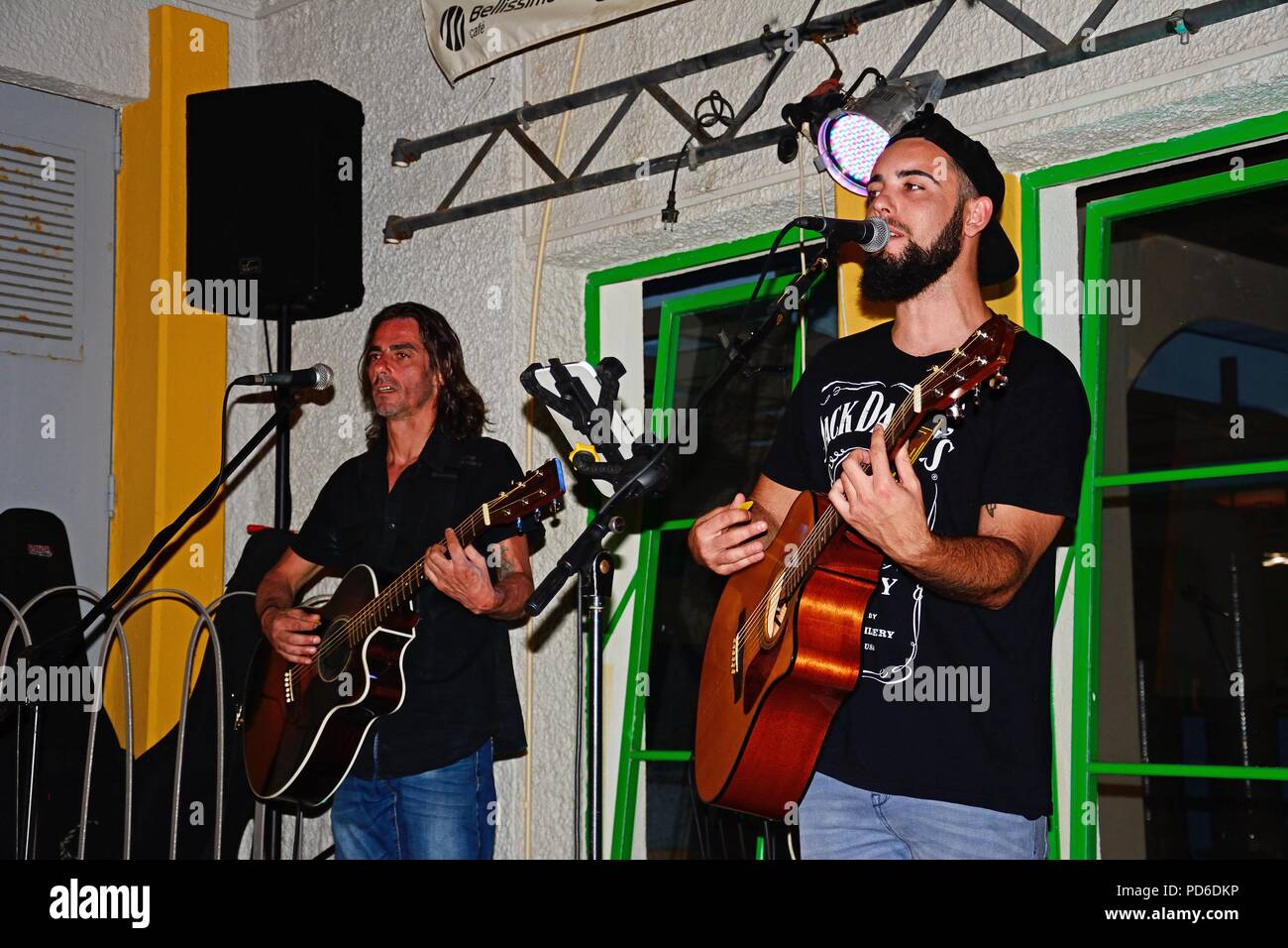 Two men singing and playing guitars in the old town at night, Albufeira, Portugal, Europe. Stock Photo