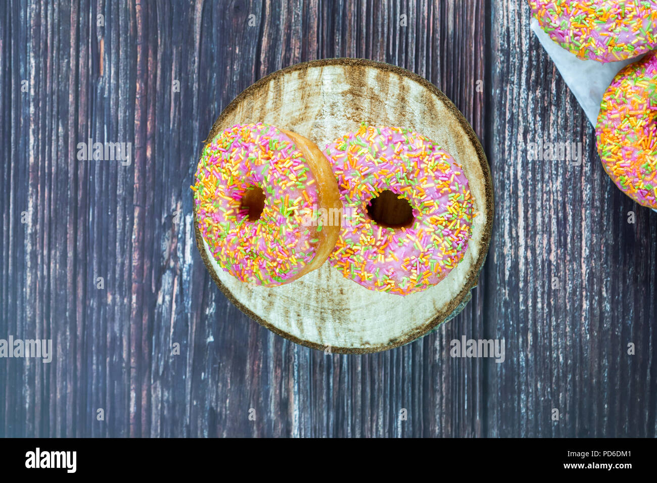 Doughnuts with colorful frosting on wooden table - top view Stock Photo ...