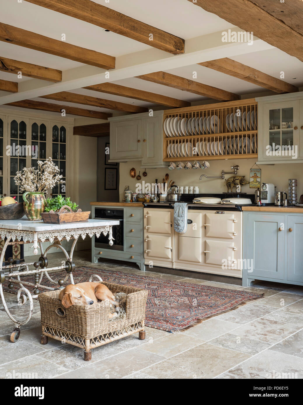 https://c8.alamy.com/comp/PD6EY5/light-blue-fitted-farmhouse-kitchen-with-plate-rack-and-sleeping-dog-in-basket-PD6EY5.jpg