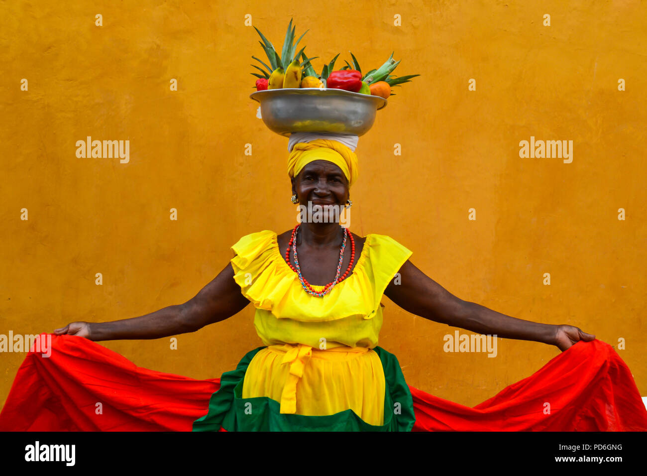 Beautiful smiling woman wearing traditional costume sell fruits in the center of Cartagena Stock Photo
