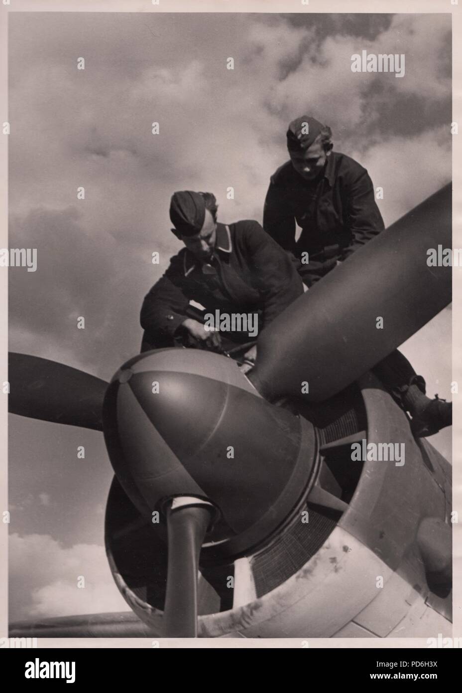 Image from the photo album of Oberleutnant Oscar Müller of  Kampfgeschwader 1: Luftwaffe ground crew of 5./KG 1 (known as 'Black Men' because of their dark overalls) work on the starboard engine of a Junkers Ju 88A-4 belonging to the unit. Stock Photo