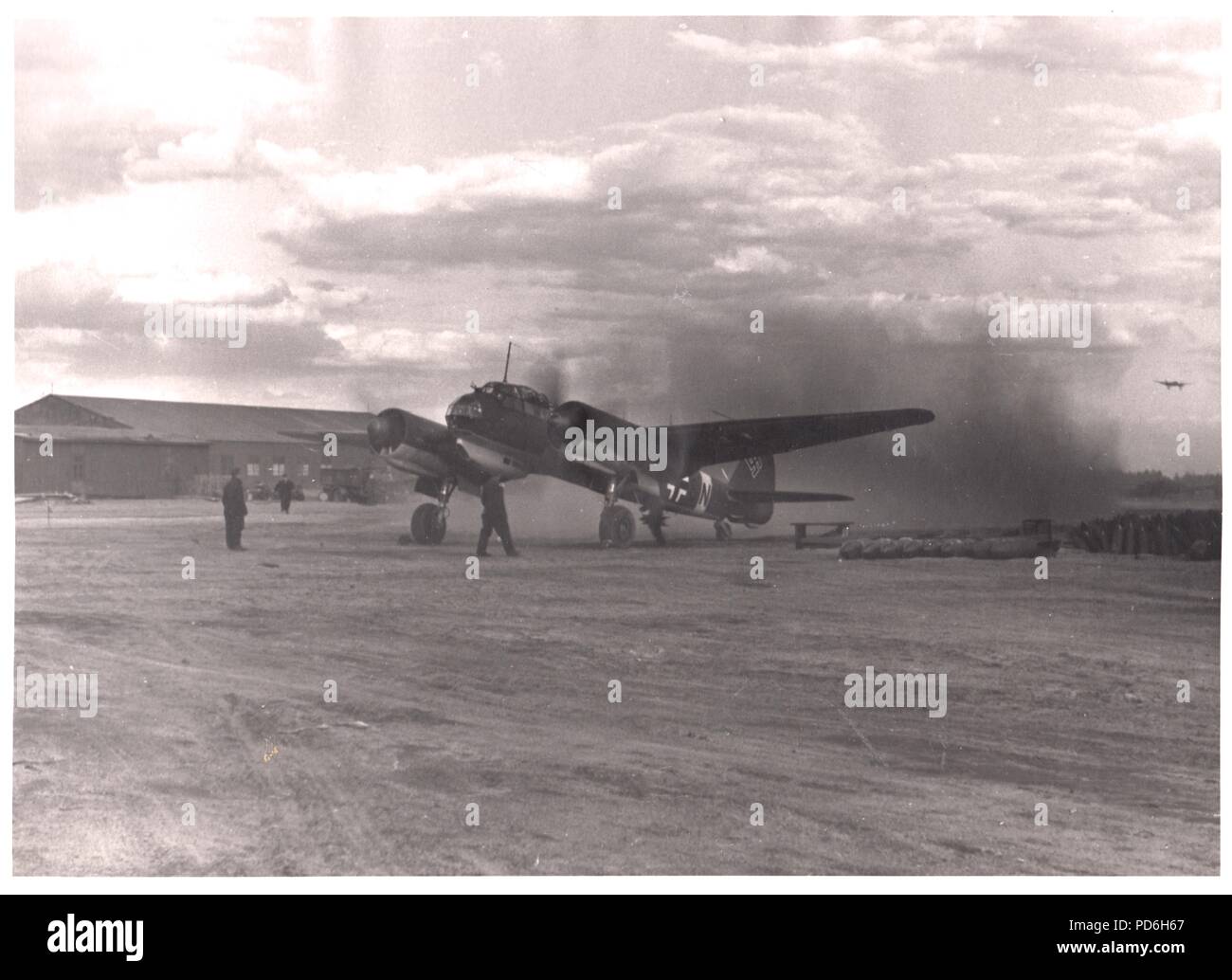 Image from the photo album of Oberleutnant Oscar Müller of  Kampfgeschwader 1: Junkers Ju88A-4 V4+SN of 5./KG 1 runs up its engines on a Russian airfield, ready for its next mission. Additional bombs are placed near to its stand for speedy re-arming. Stock Photo