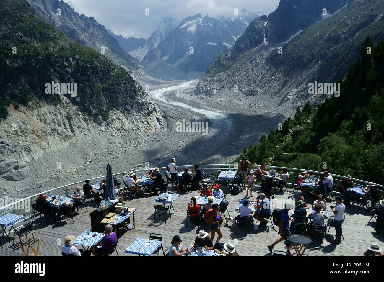 Tourists on terrasse of restaurant at Montenvers with view over La Mer de Glace, Mont blanc massiv, French alps, France Stock Photo