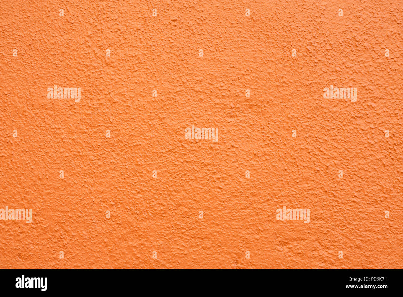 Stucco wall - Orange stucco textured wall background with natural light. Stock Photo