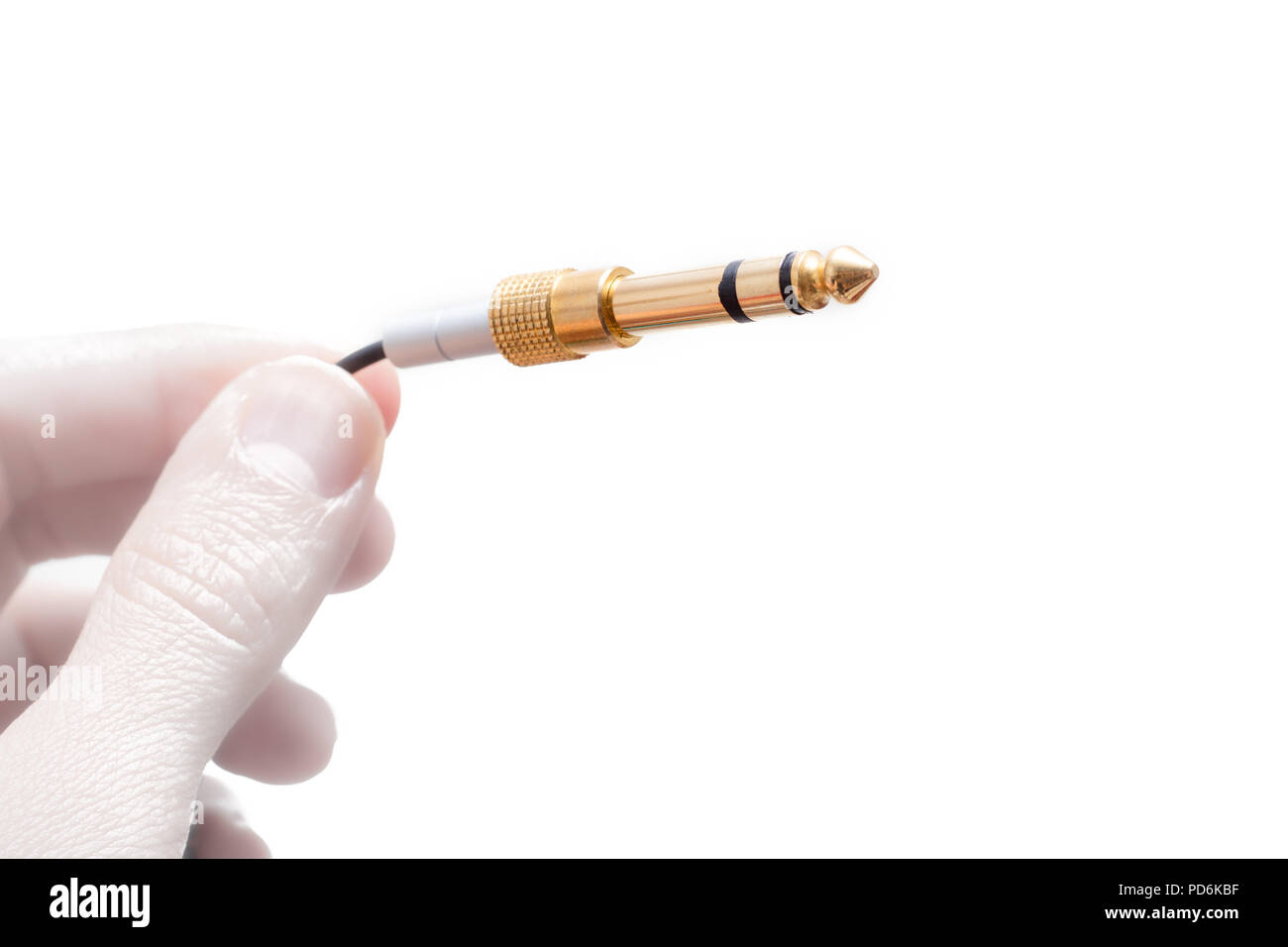 Hand with stereo audio cable gold coated adapter isolated on white ...