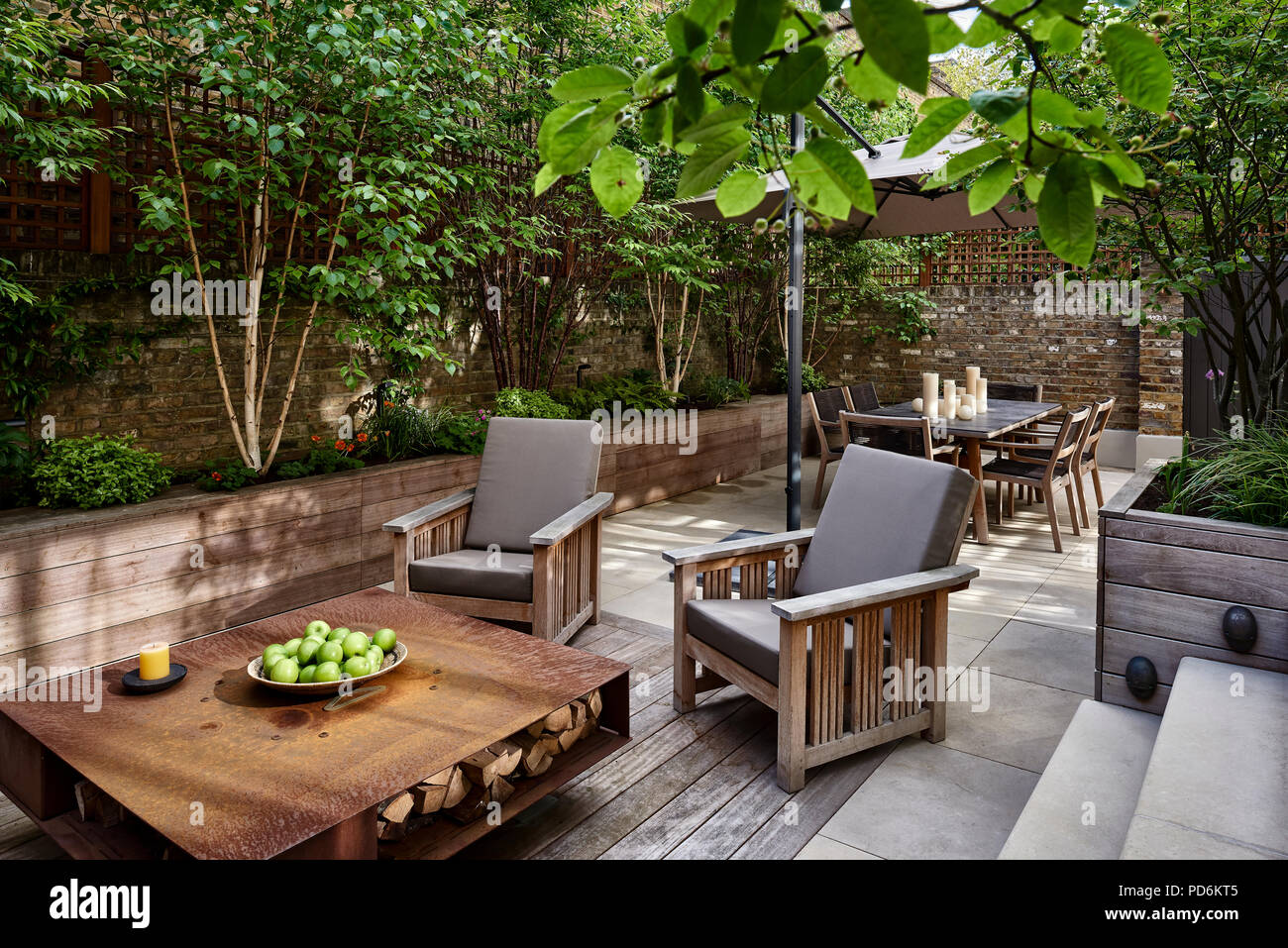 Apples on coffee table with garden seating in courtyard garden of Victorian London home Stock Photo