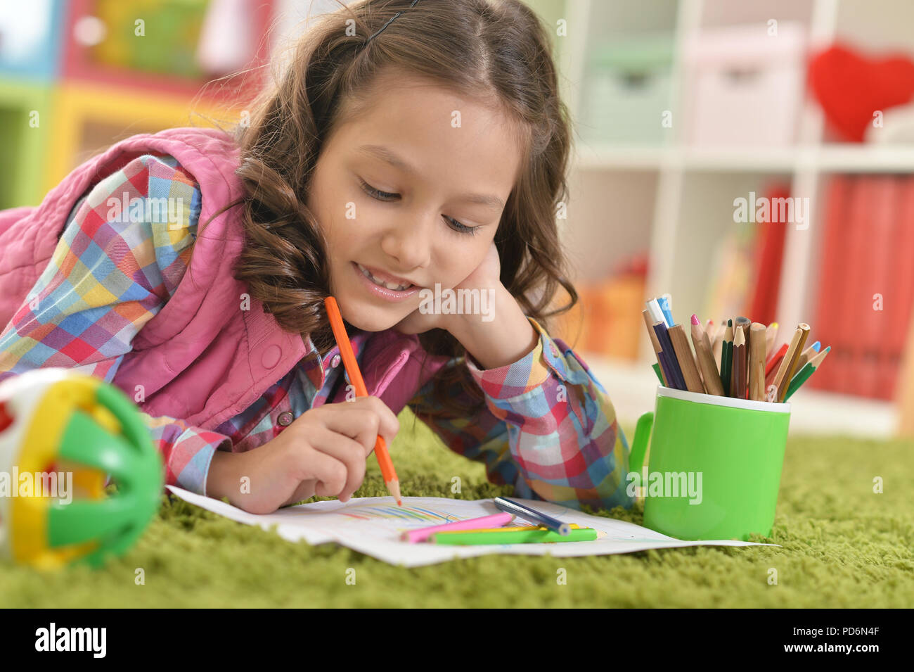 cute smiling girl lying on floor and drawing at home Stock Photo - Alamy