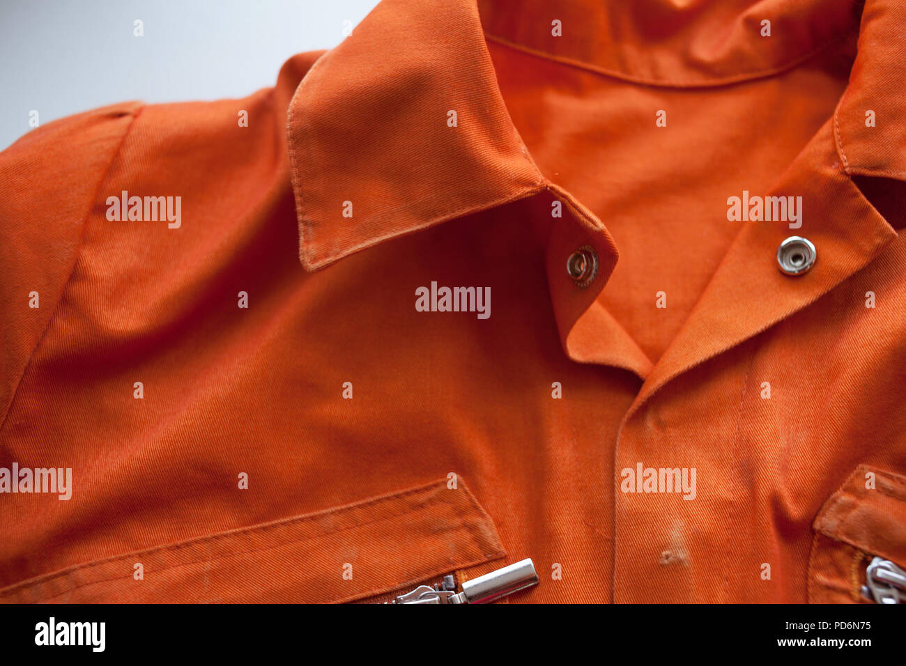 An orange jumpsuit of a prisoner. close up. Serving of compulsory execution of court decisions Stock Photo