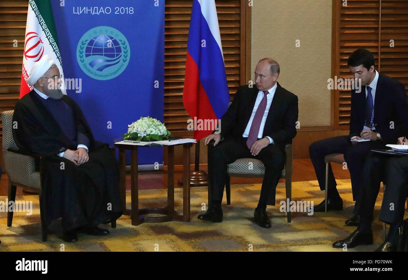 Russian President Vladimir Putin, right, holds a bilateral meeting with Iranian President Hassan Rouhani on the sidelines of the Shanghai Cooperation Organisation Summit June 9, 2018 in Qingdao, China. Stock Photo