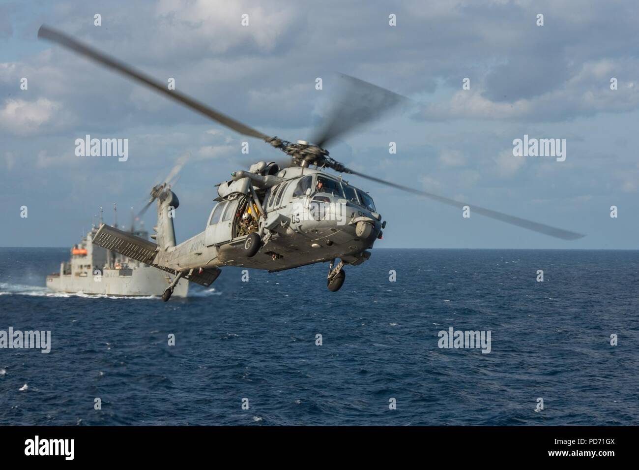An MH-60S Sea Hawk helicopter assigned to Helicopter Sea Combat Squadron (HSC) 25 returns to the Military Sealift Command dry cargo and ammunition ship USNS Washington Chambers (T-AKE 11). Stock Photo
