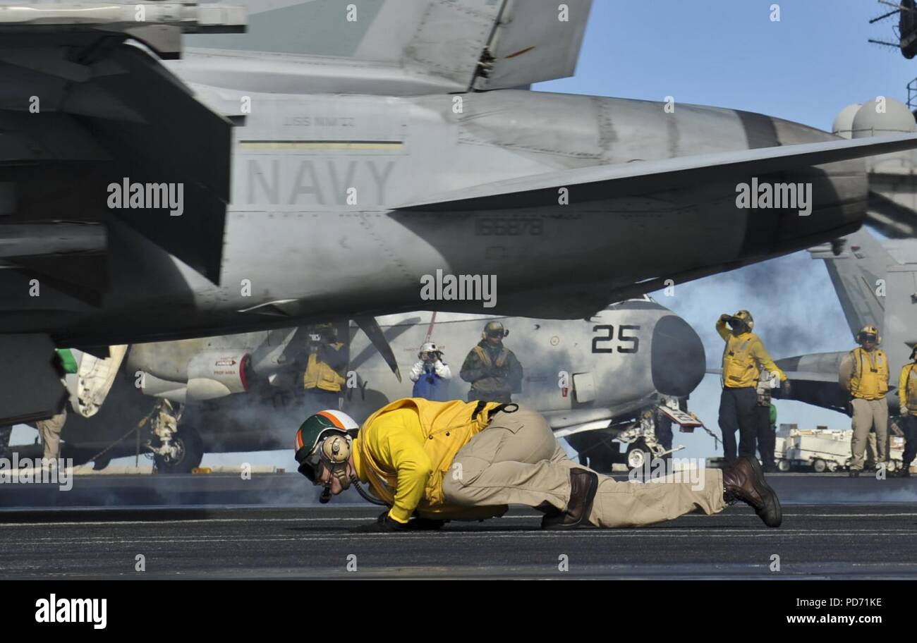 An officer ducks as an F-A-18F launches. (8185239012). Stock Photo