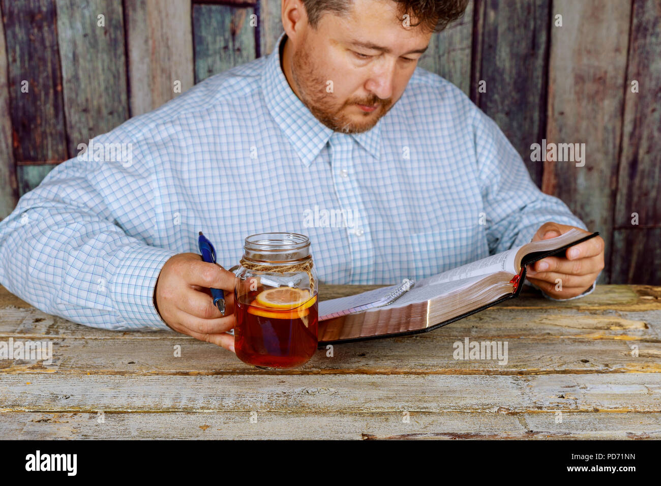 A middle aged man studying and reading Holy Bible Stock Photo