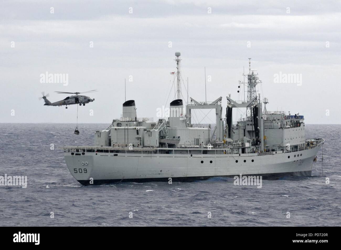 An SH-60 assists HMCS Protecteur. (12907351925). Stock Photo