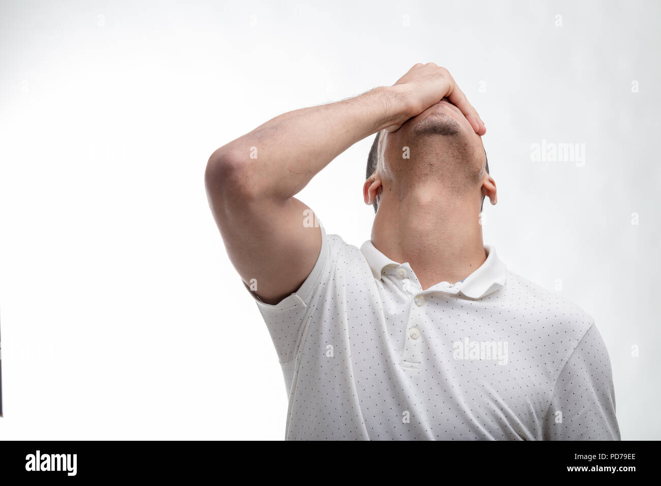 Man covering his face with his hand as he tilts his head back isolated in a front view on white