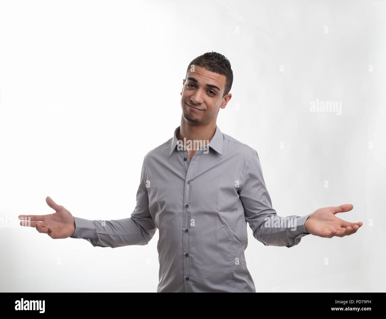 Charismatic man shrugging his shoulders with outstretched arms and a wry smile isolated on white Stock Photo