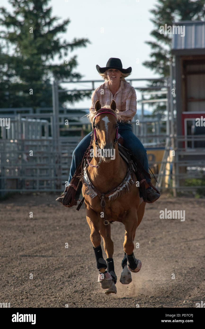 A Teenage girl on horseback competes in the Pole Bending Competition at