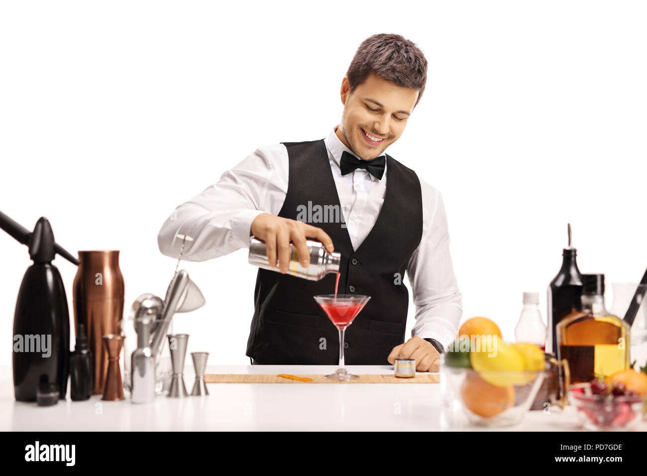 Barman pouring his signature cocktail in a glass isolated on white background Stock Photo