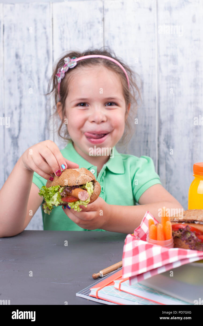 A little girl is eating her lunch at school. Lunch schoolgirl. Toast