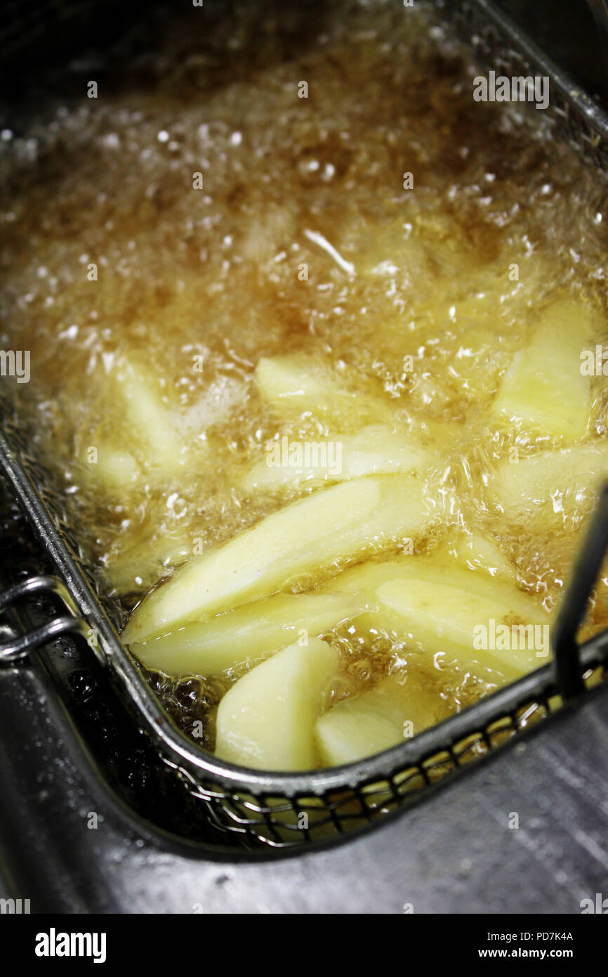 frying chipped potatoes in deep fat fryer Stock Photo Alamy
