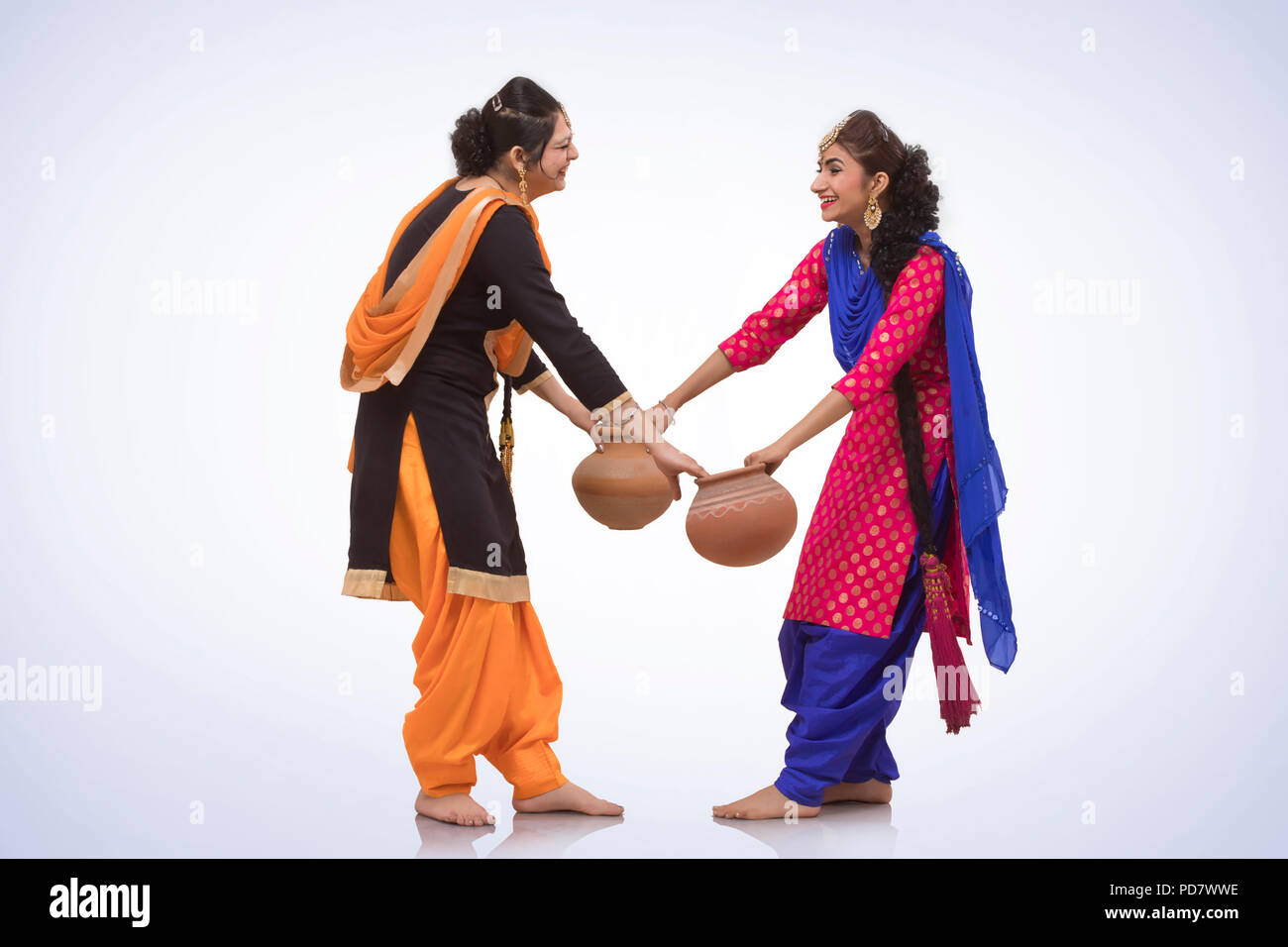 Two Women Dancing with Earthen Pot Stock Photo