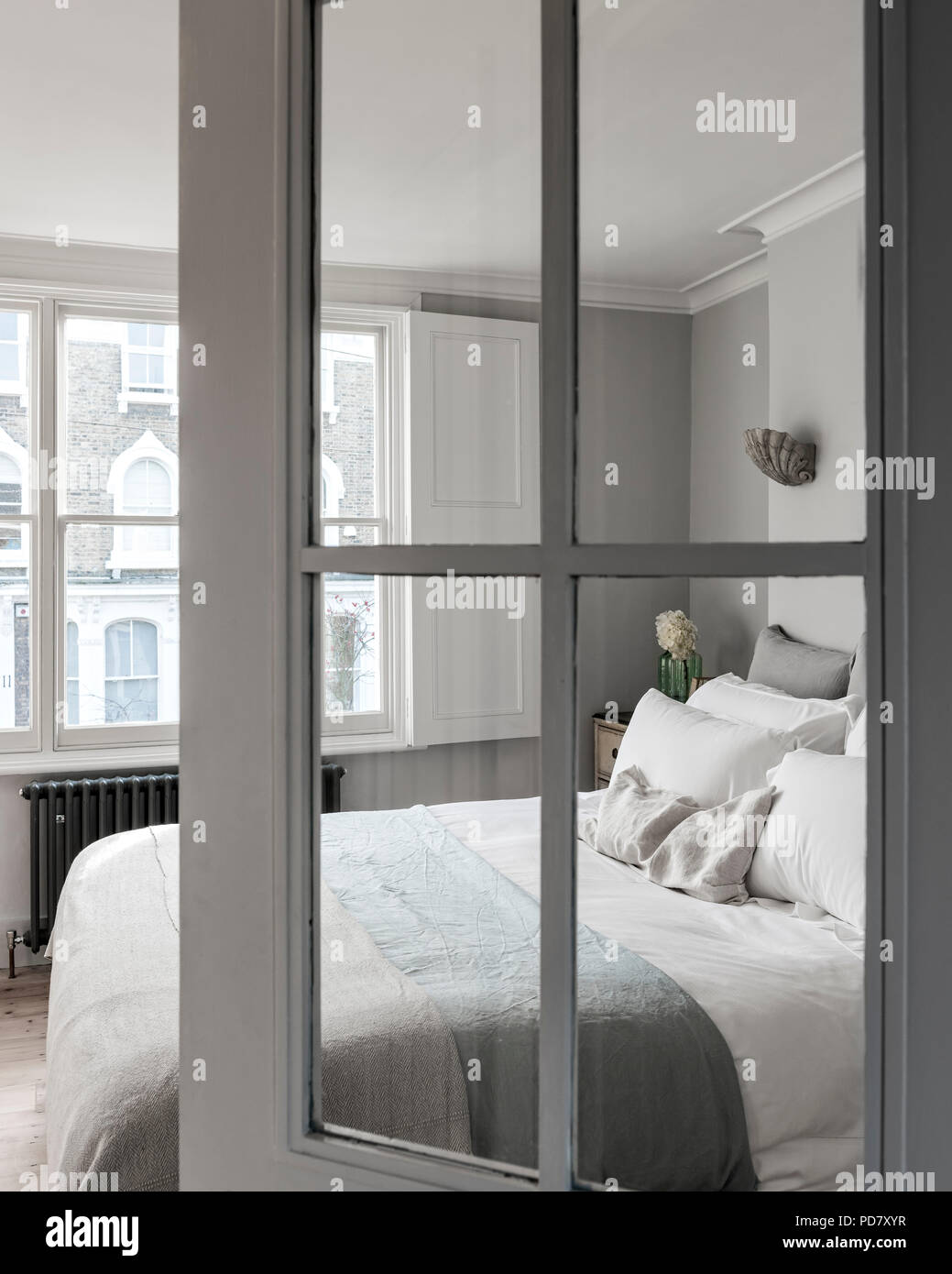 View through glass panelled door into elegant bedroom. Stock Photo