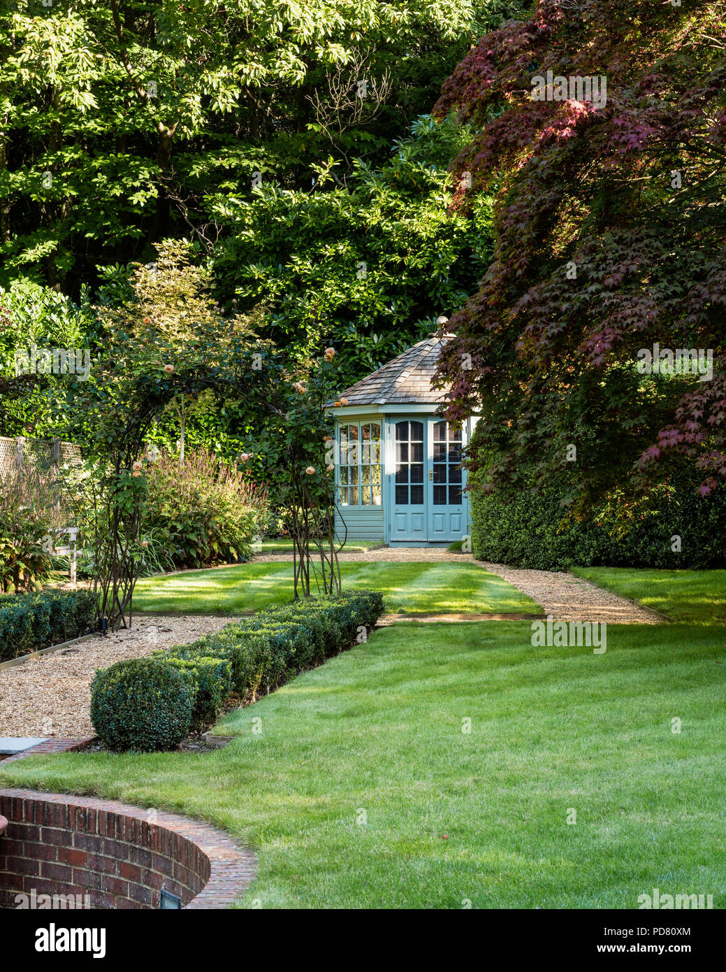 Neat country garden with box hedge and summer house Stock Photo
