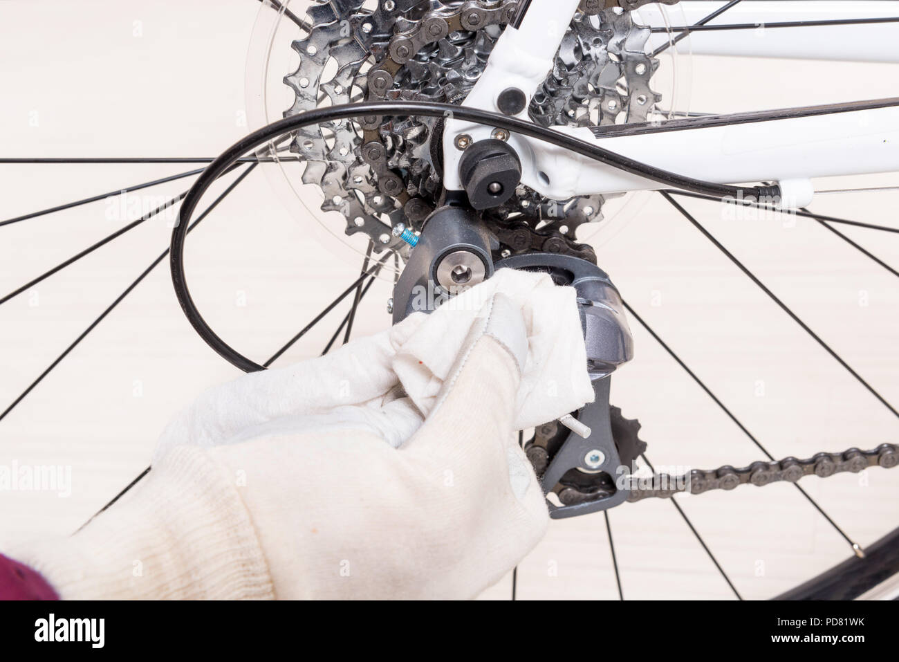 Preparing bicycle for a new season. Hand with cloth cleaning derailleur