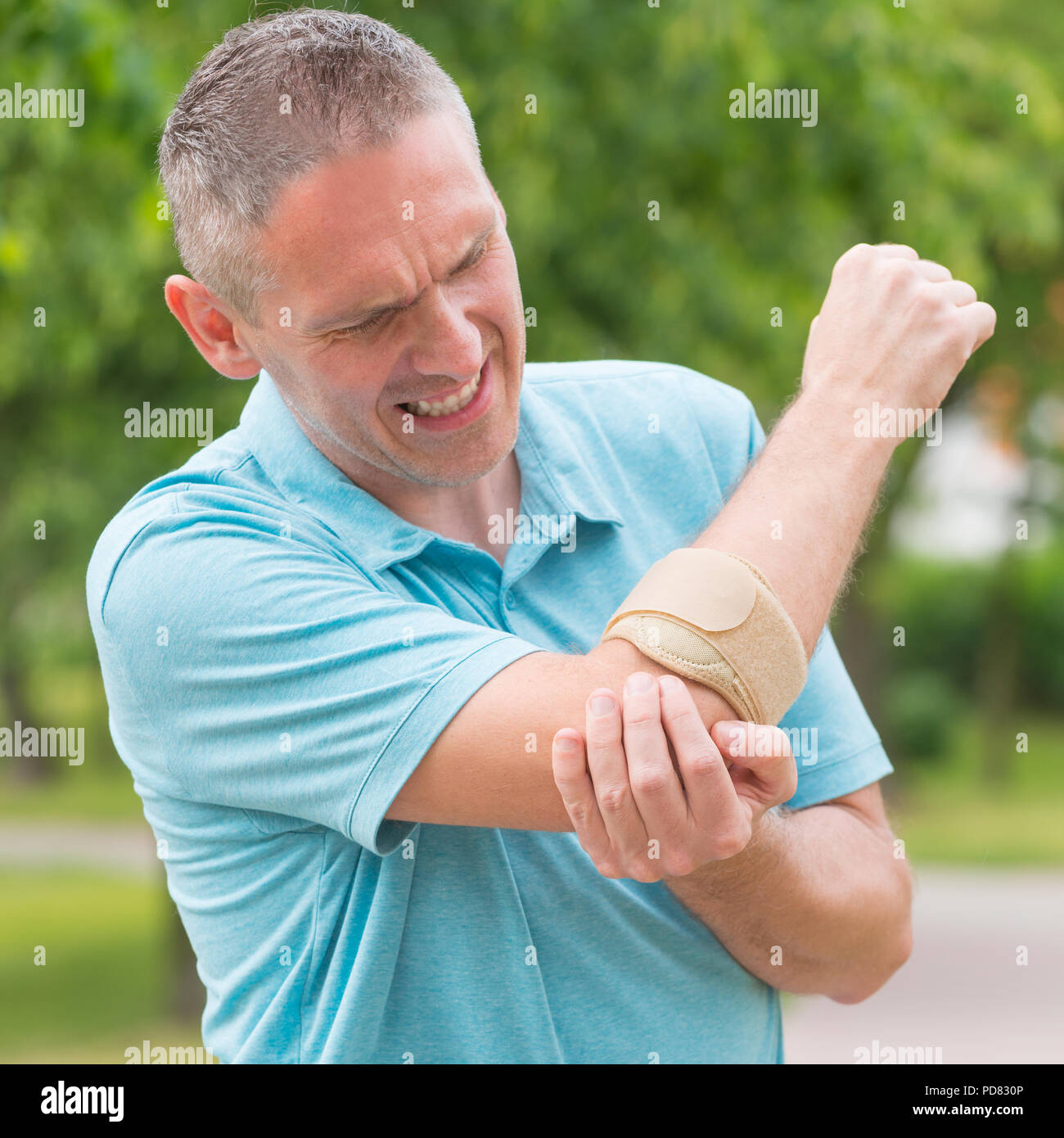 Man wearing elbow brace to reduce pain Stock Photo Alamy