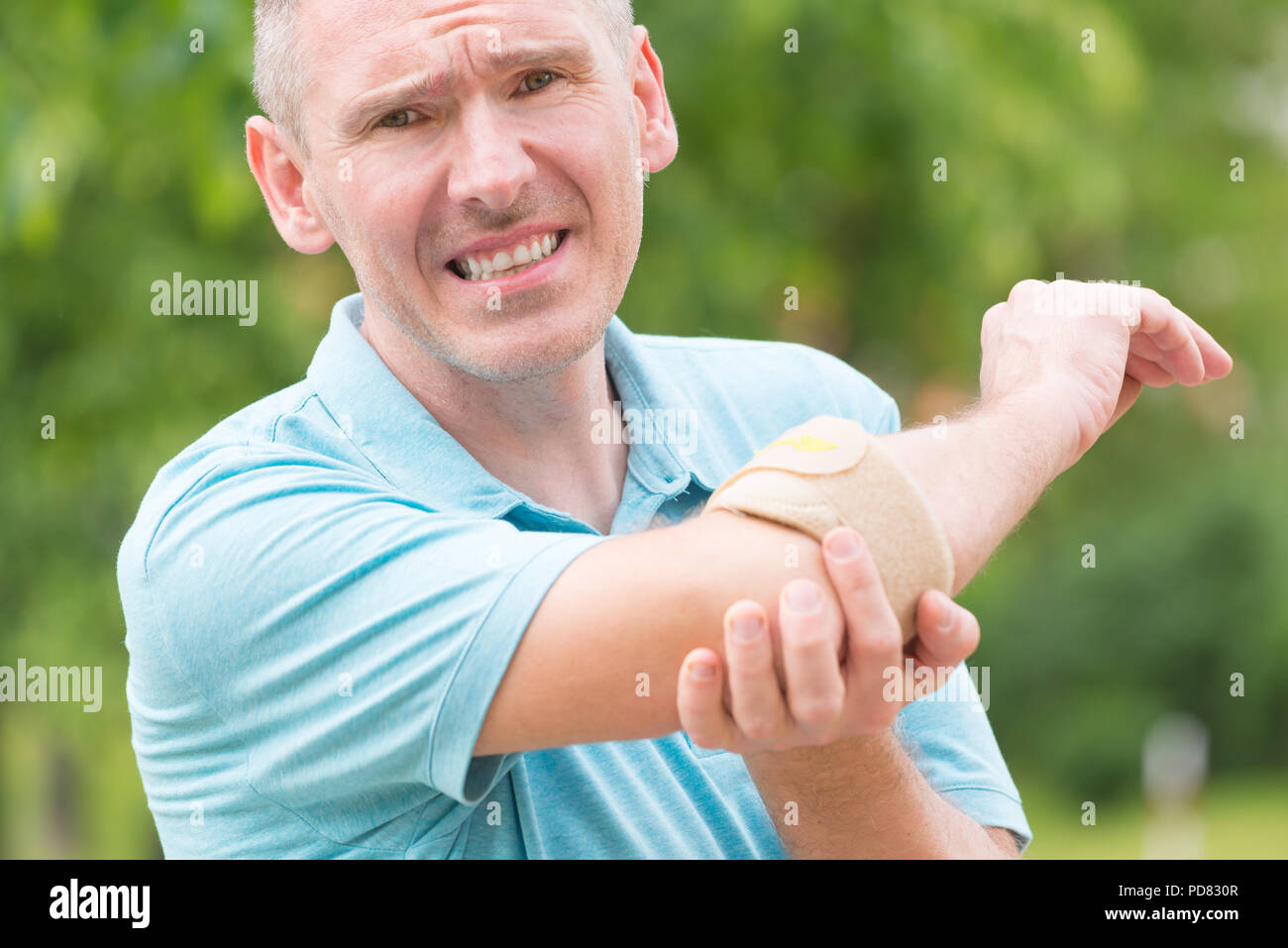 Man wearing elbow brace to reduce pain Stock Photo Alamy