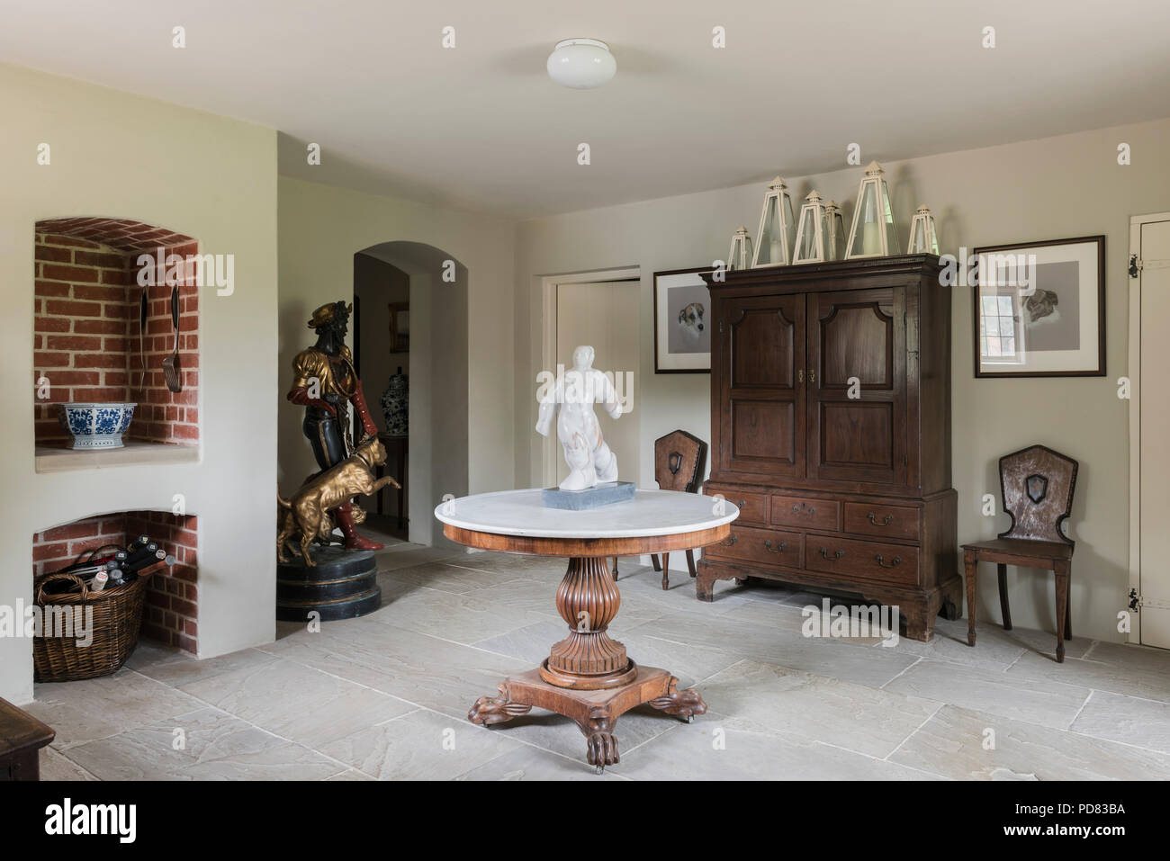 Claw footed table with marble top in entrance hall with flagstone flooring Stock Photo