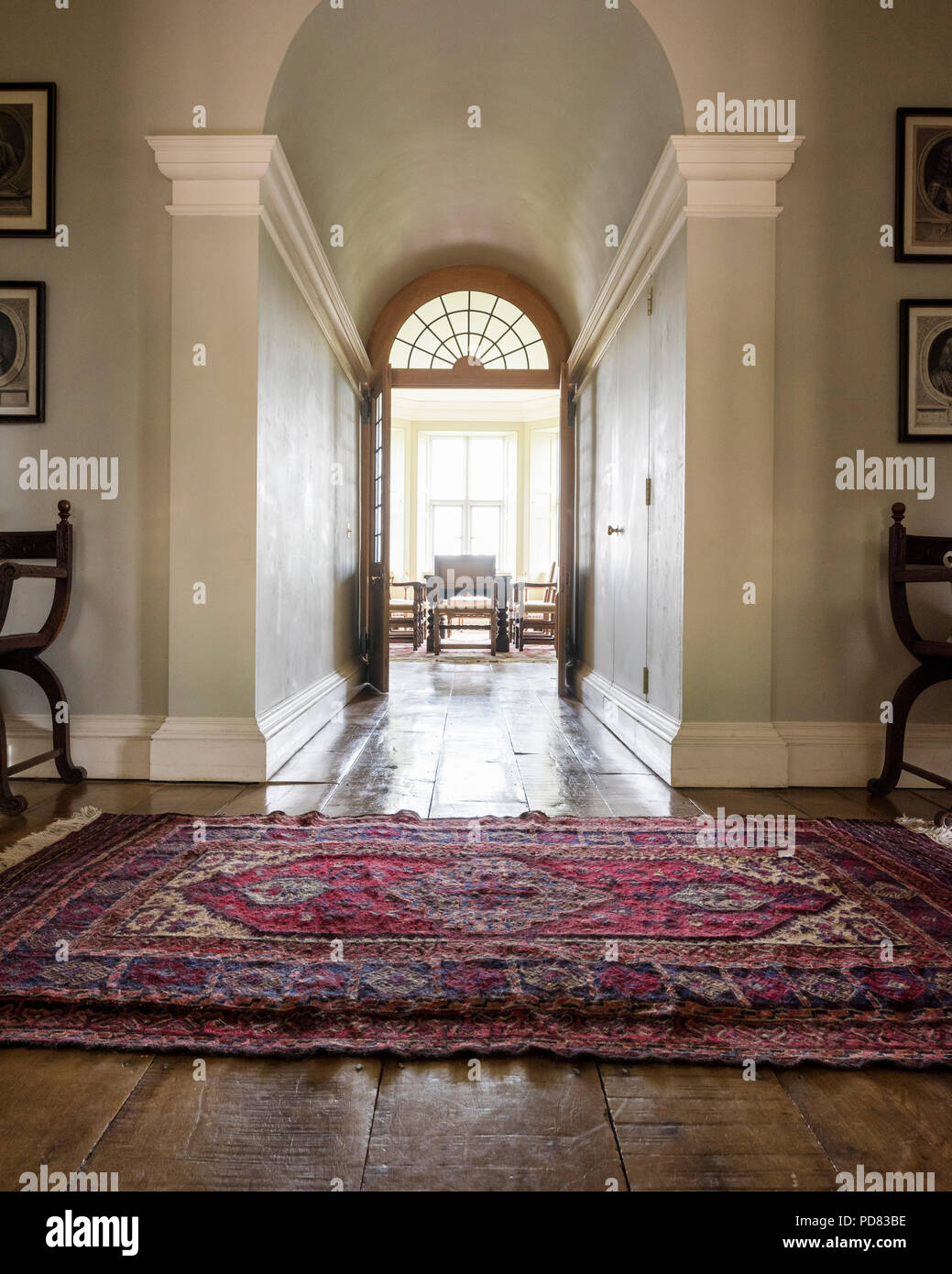 Antique rug in hall leading through to dining room with double doors Stock Photo