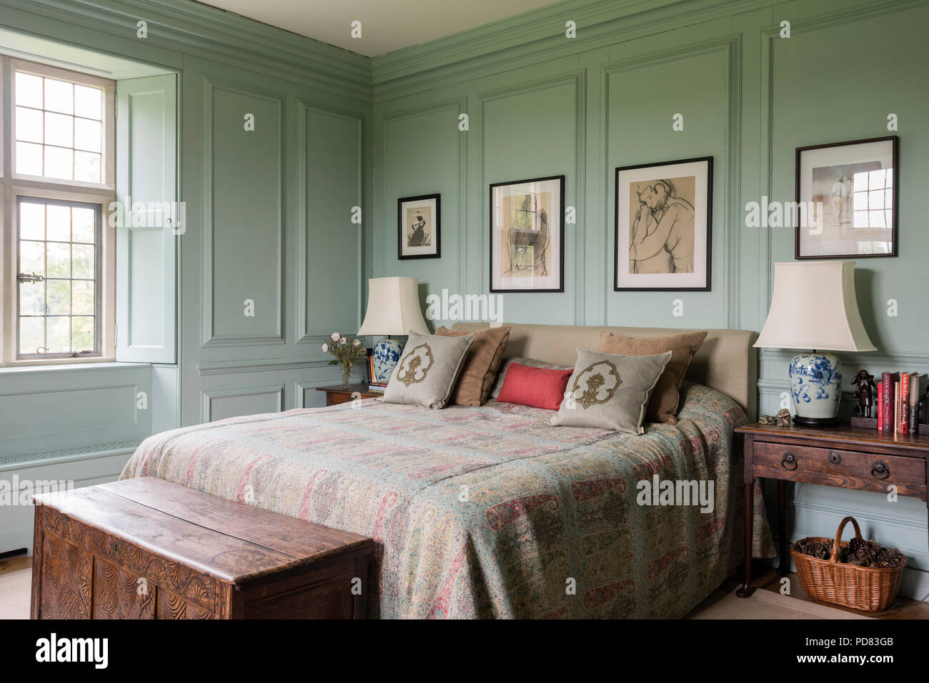 Wool and silk bedcover from Le Cuona in bedroom with wall panelling painted in Farrow & Ball's Powder Blue. Stock Photo