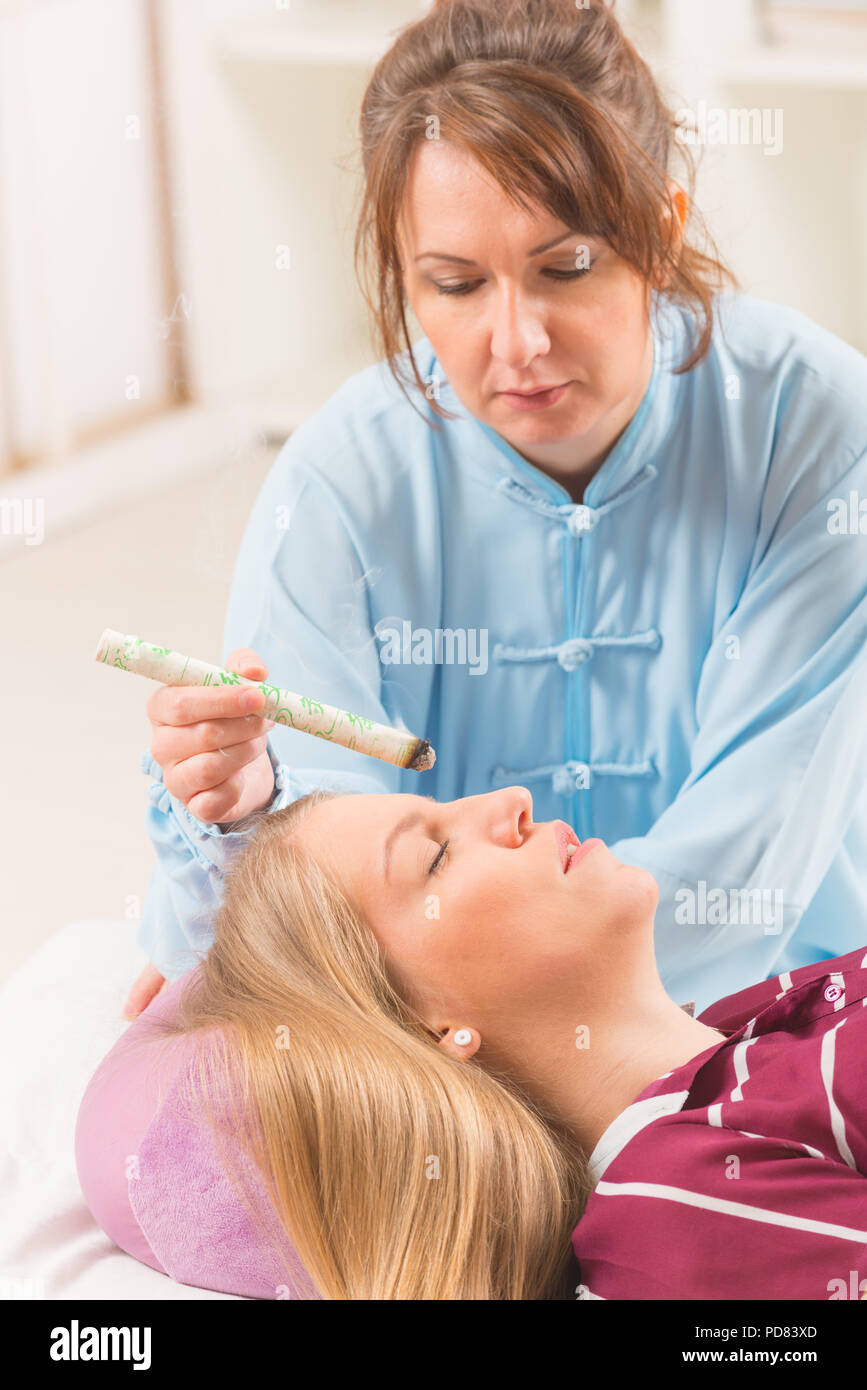 Alternative medicine therapist doing moxa treatment on her client Stock Photo Alamy