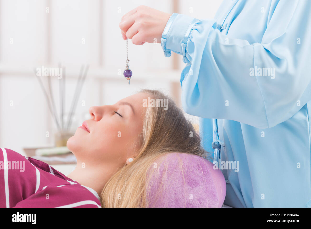 Alternative medicine therapist using pendulum to make a diagnosis Stock