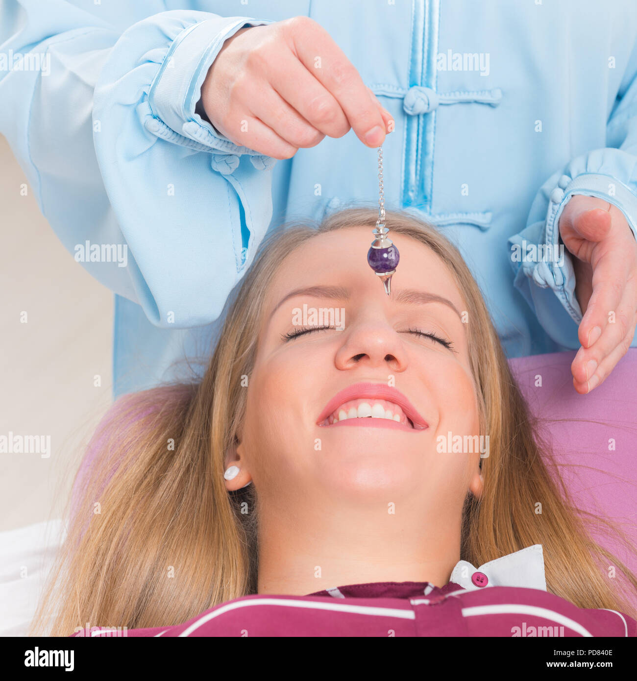 Alternative medicine therapist using pendulum to make a diagnosis Stock