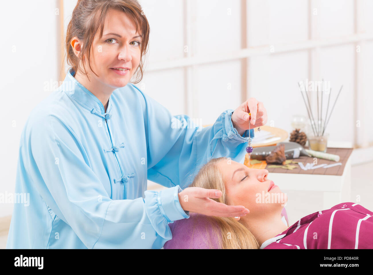 Alternative medicine therapist using pendulum to make a diagnosis Stock