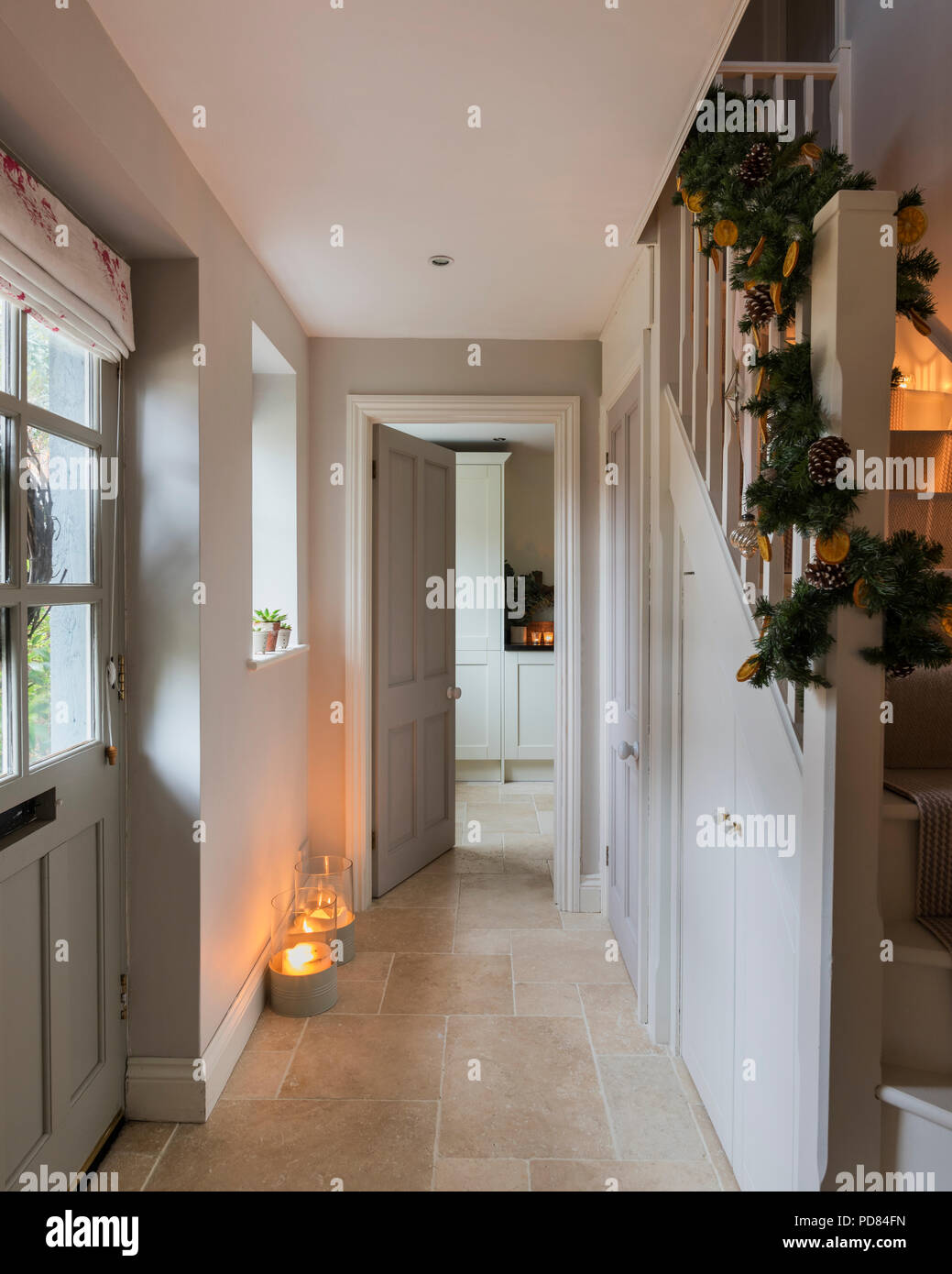 Candle lit entrance hall with decorative festive greenery winding up