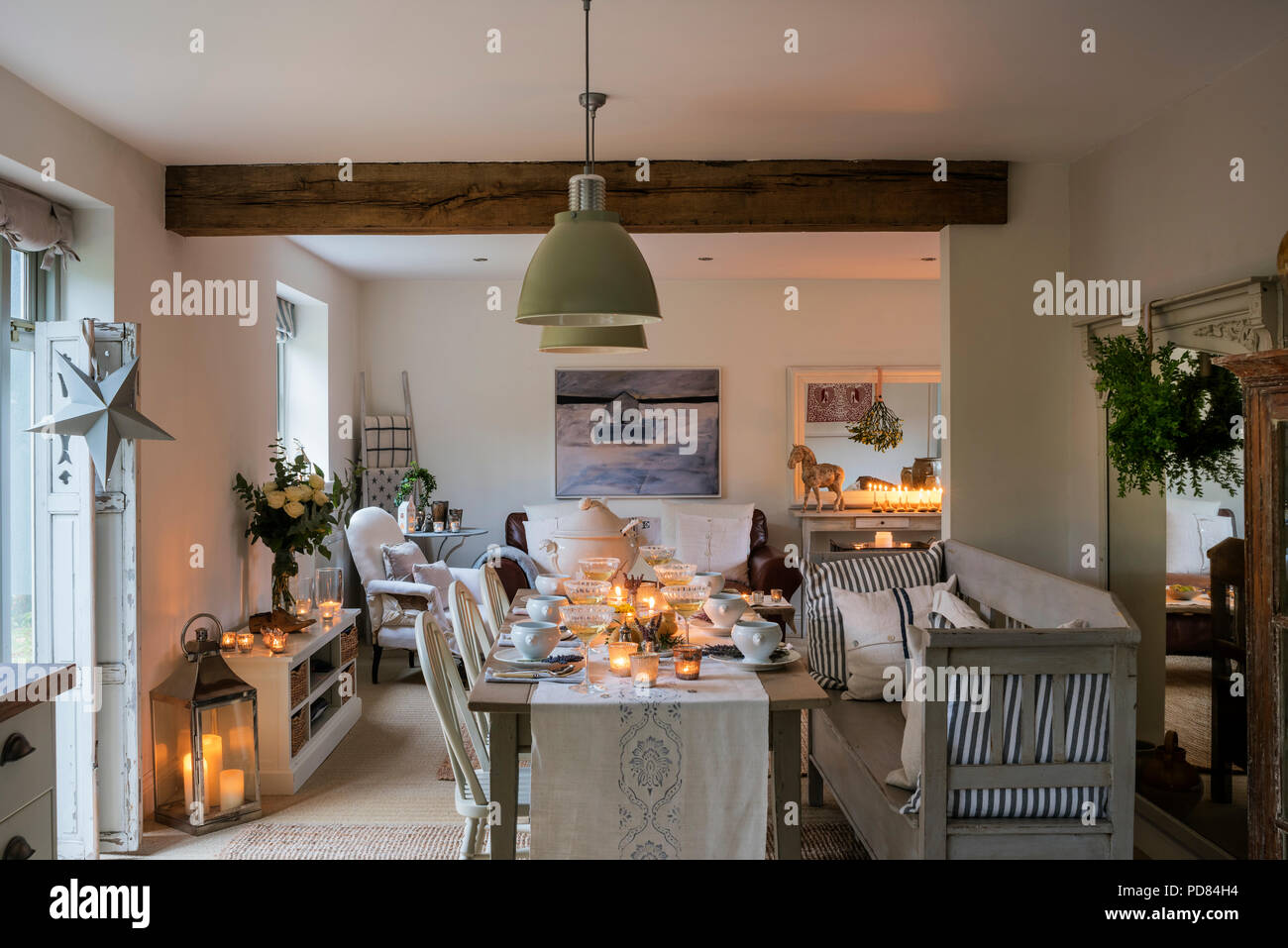 Candle Lit Dining Table In Rustic Cottage Kitchen With Beamed