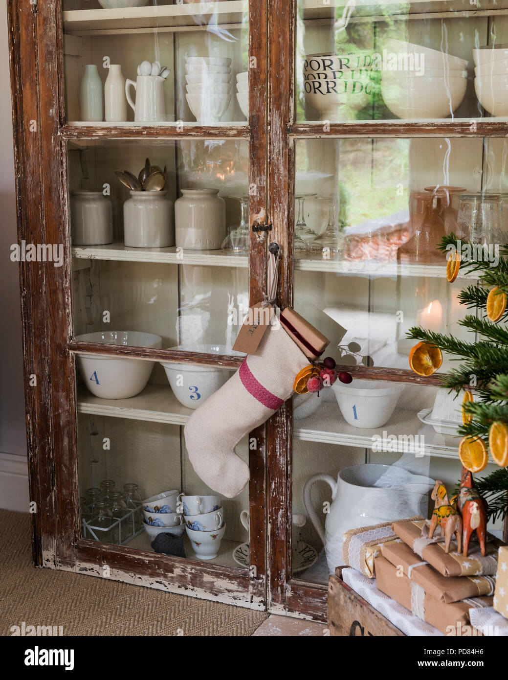 Rustic glass fronted display cabinet full of table and glassware Stock Photo