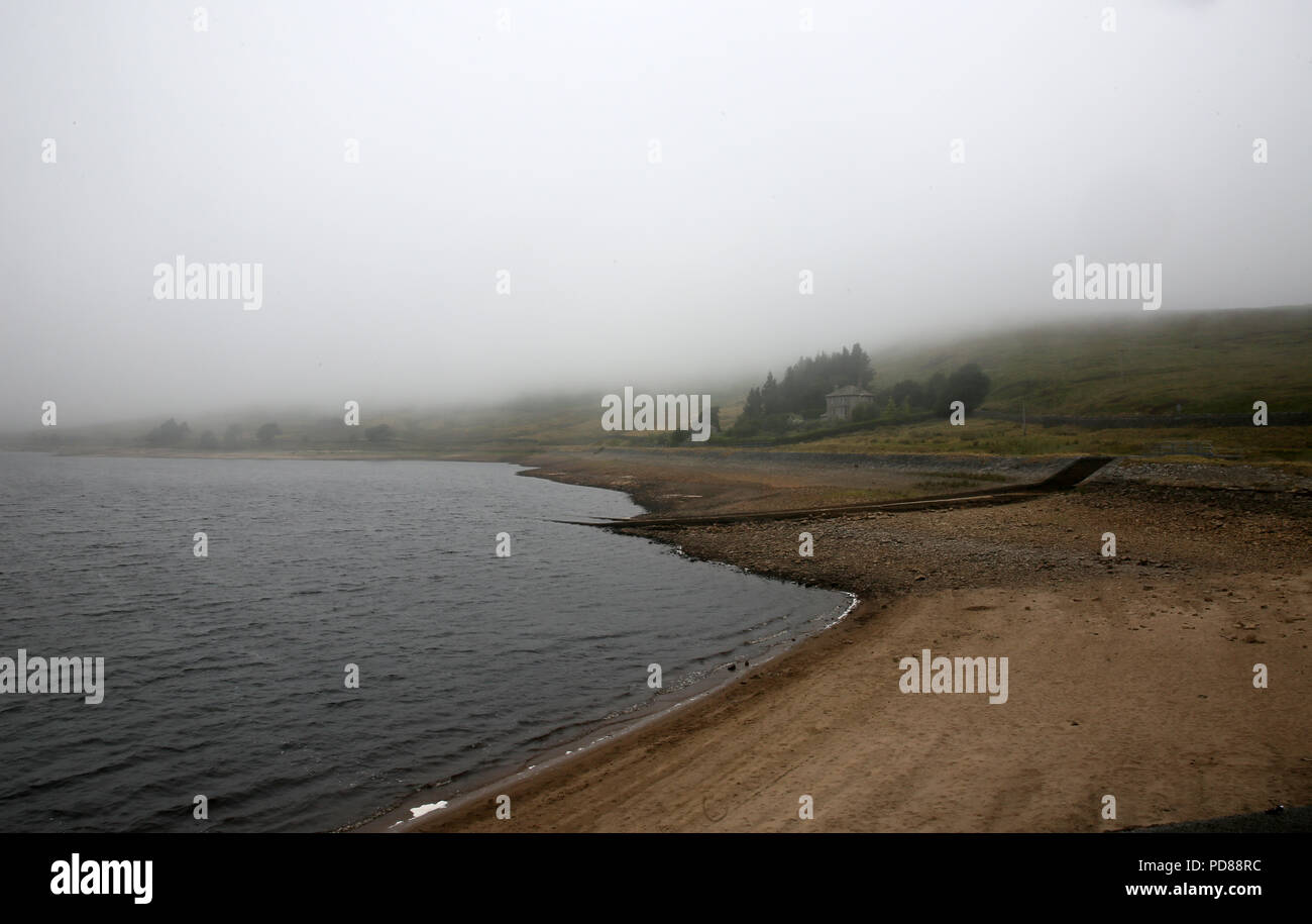 Calderdale, UK. 7th August 2018. Mist covers the landscape above Widdop Reservoir where water levels remain low despite milder weather.  The reservoir is a source for Yorkshire water. Widdop, Hebden Bridge, Calderdale, 7th August, 2018 (C)Barbara Cook/Alamy Live News Stock Photo