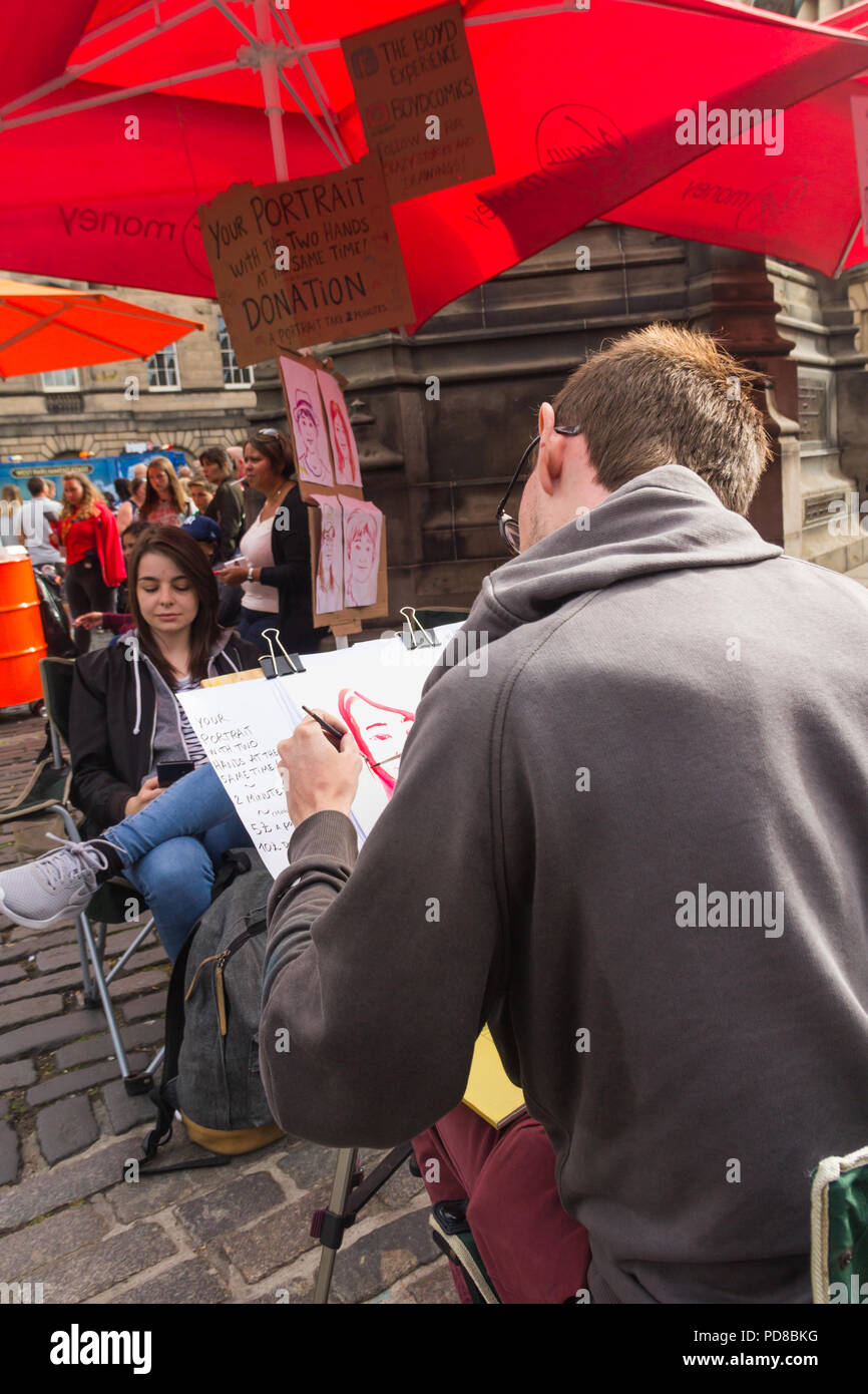 Edinburgh, Scotland, UK. 7th August 2018. Street acts and artists, alongside promoters of Fringe Festival events, ply the streets of Edinburgh Festival, providing entertainment and amusement to the many visitors to the Fringe. This ambidextrous artist produced portraits in a two minute sitting. Credit Joseph Clemson, JY News Images/Alamy. Stock Photo