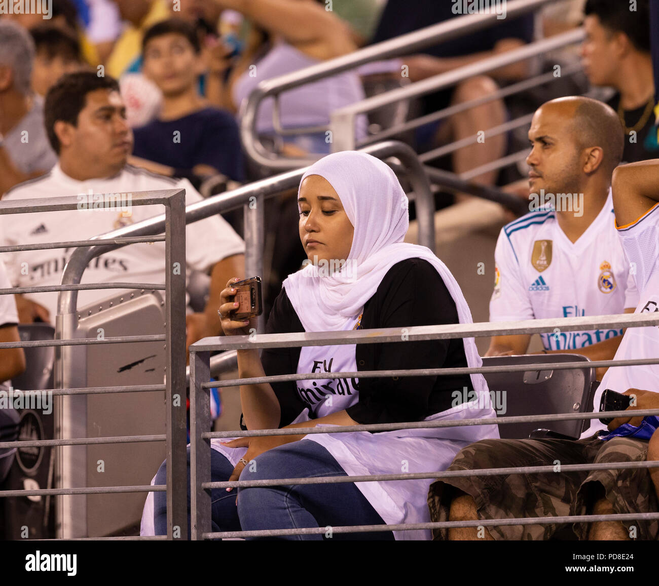 East Rutherford, NJ - August 7, 2018 Muslim woman fan of Real Madrid making video with cell phone during ICC game against AS Roma at MetLife stadium Real won 2