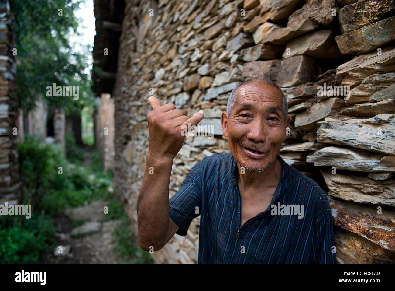 Luonan, China's Shaanxi Province. 7th Aug, 2018. Liu Changsuo, 63 years old, is the only resident living in the slate buildings on the moungtain in Jin'an Village at Shipo Township of Luonan County, northwest China's Shaanxi Province, Aug. 7, 2018. The ancient slate building complex in the Qinling Mountains, also called 'daziliang' by local people, is recognized as 'a living fossil of ancient folk houses in Qinling Mountains'. Credit: Tao Ming/Xinhua/Alamy Live News Stock Photo